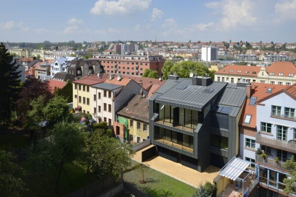 Dům s tmavou fasádou a světlými interiéry